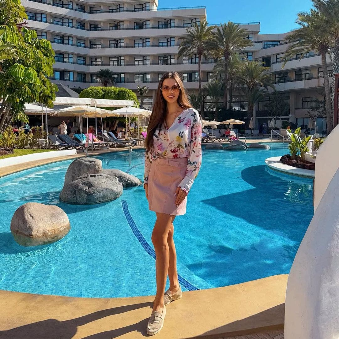 Woman posing in the H10 Conquistador swimming pool on a bright, sunny day.