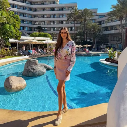 Woman posing in the H10 Conquistador swimming pool on a bright, sunny day.
