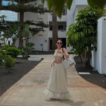 Woman in summer beachwear walking along the pathways at H10 Suites Lanzarote Gardens.
