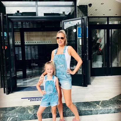Blonde woman and her daughter in matching outfits at the entrance of H10 Cambrils Playa.