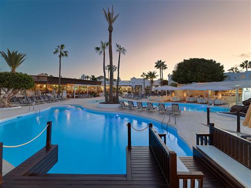 Blick auf das Hotel und den Pool bei Sonnenuntergang