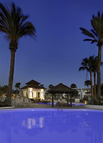 Vue panoramique de l'hôtel et la piscine à la tombée de la nuit