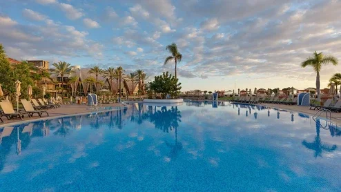 Blick auf das Hotel und den Pool bei Sonnenuntergang